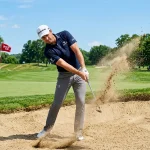 Golfer hitting out of a bunker, demonstrating the best wedge bounce for average golfer